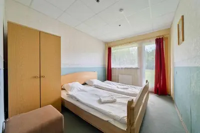 a bedroom with a bed and a window at Poilsio kompleksas Tolieja Vieta renginiams bei poilsiui ant ežero kranto in Kulionys
