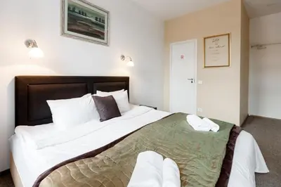 a bedroom with a large bed with white sheets at Happy Inn in Kaunas