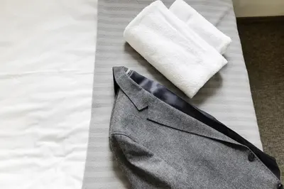 a gray suit and a white sock on a bed at Happy Inn in Kaunas