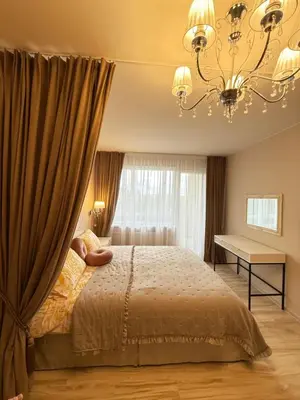a bedroom with a bed and a chandelier at Studio apartment Morkus 2 in Šiauliai