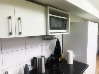 a kitchen with a microwave and a black counter top at Studio 10 min walk from old town in Vilnius