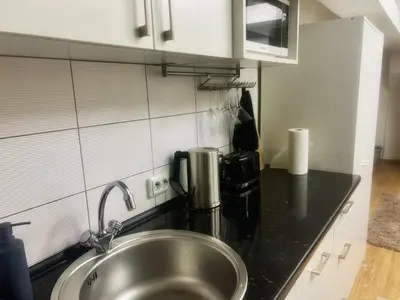 a kitchen with a stainless steel sink in a kitchen at Studio 10 min walk from old town in Vilnius