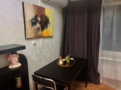 a dining room table with a painting on the wall at Studio 10 min walk from old town in Vilnius