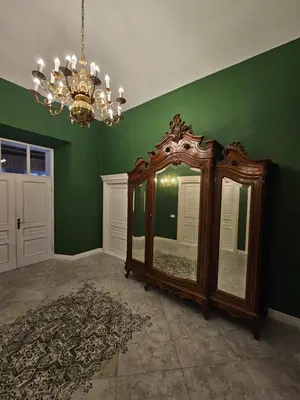 a green room with a large mirror and a chandelier at Bistrampolio dvaro Jackaus Vila