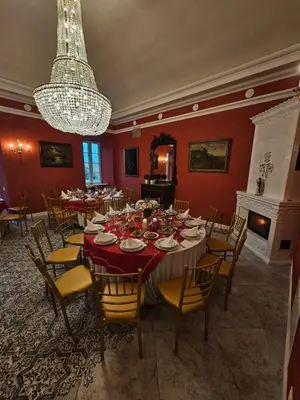 a dining room with a table and chairs and a chandelier at Bistrampolio dvaro Jackaus Vila