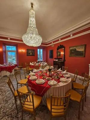 a dining room with a table and chairs and a chandelier at Bistrampolio dvaro Jackaus Vila