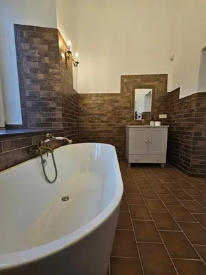 a large bathroom with a tub and a sink at Bistrampolio dvaro Jackaus Vila