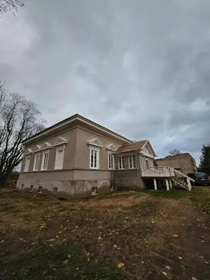 a large house on a hill with a car parked in front at Bistrampolio dvaro Jackaus Vila