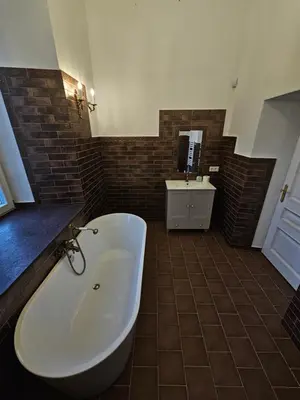 a large bathroom with a tub and a sink at Bistrampolio dvaro Jackaus Vila
