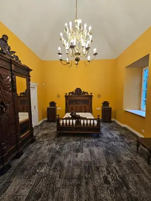 a bedroom with a bed and a chandelier at Bistrampolio dvaro Jackaus Vila