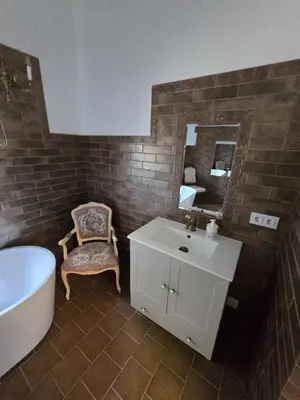a bathroom with a sink and a tub and a mirror at Bistrampolio dvaro Jackaus Vila