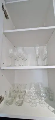 a bunch of wine glasses sitting on a shelf at Korsako apartamentai in Šiauliai