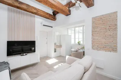 a living room with white furniture and a brick wall at Central Bright I Etmonu st I Easy Check in I Cᴏʜᴏsᴛ in Vilnius