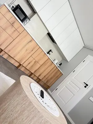 a kitchen with white cabinets and a wooden counter top at Relaxation Corner on Kranto in Kaunas