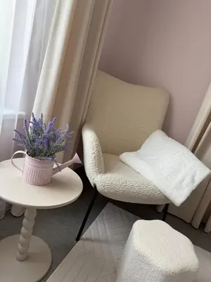 a chair and a table with a vase of purple flowers at Relaxation Corner on Kranto in Kaunas