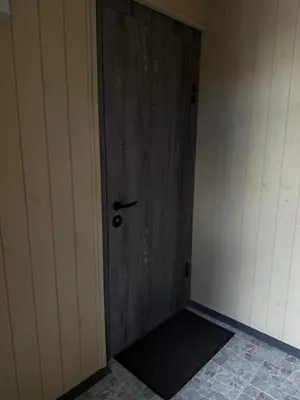 a wooden door with a black mat in a room at Relaxation Corner on Kranto in Kaunas