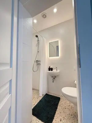 a white bathroom with a toilet and a sink at Relaxation Corner on Kranto in Kaunas