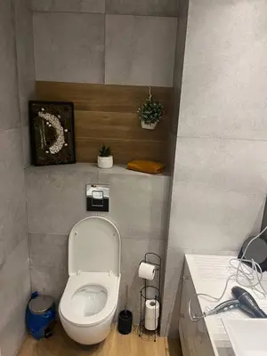 a bathroom with a white toilet and a sink at Modern flat in Vilnius