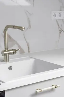 a white kitchen sink with a chrome faucet at Traku apartament in Pakopi