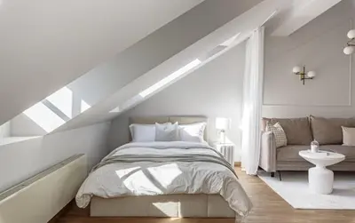 a white bedroom with a bed and a couch at Traku apartament in Pakopi