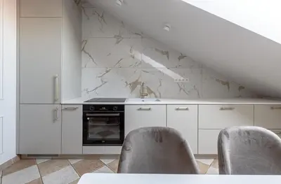 a kitchen with white cabinets and a stove at Traku apartament in Pakopi