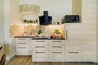 a kitchen with white cabinets and a sink at Old Town Apartment in Jonava