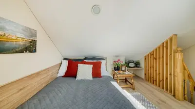 a bedroom with a bed with red pillows at Old Town Apartment in Jonava