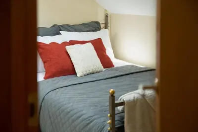a bedroom with a bed with red and white pillows at Old Town Apartment in Jonava