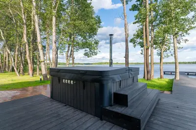 a black trash can on a wooden deck next to a lake at Galuonu vilos Ezero in Inturkė