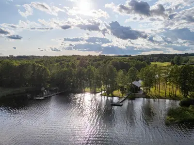 an aerial view of a lake with trees and a house at Galuonu vilos Ezero in Inturkė