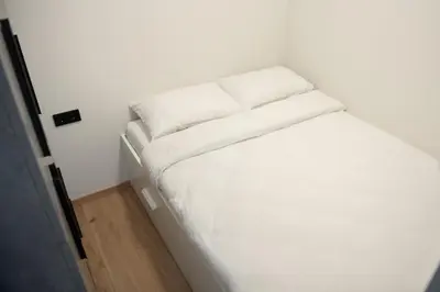 a white bed in a small room with at Sunlit City Loft- Prime Views in Vilnius