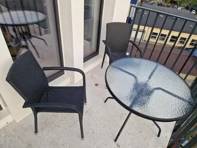 two chairs and a table on a balcony at Sunlit City Loft- Prime Views in Vilnius