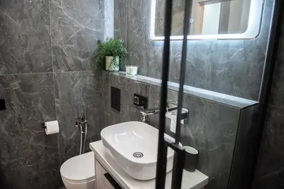 a bathroom with a sink and a toilet at Sunlit City Loft- Prime Views in Vilnius