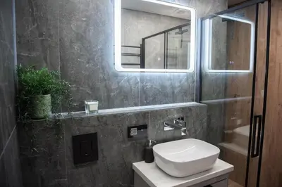 a bathroom with a toilet and a sink and a mirror at Sunlit City Loft- Prime Views in Vilnius
