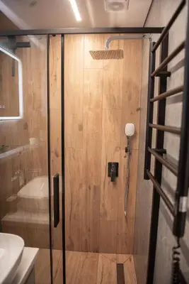a shower with a glass door in a bathroom at Sunlit City Loft- Prime Views in Vilnius