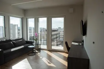 a living room with a couch and a large window at Sunlit City Loft- Prime Views in Vilnius