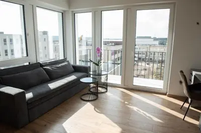 a living room with a couch and some windows at Sunlit City Loft- Prime Views in Vilnius
