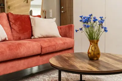 a living room with a couch and a vase of flowers on a table at Silence of Uzupis - Self Check in in Vilnius