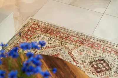 a rug on a floor with blue flowers on it at Silence of Uzupis - Self Check in in Vilnius