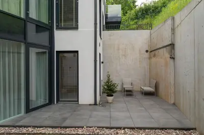 a patio with two chairs and a potted plant at Silence of Uzupis - Self Check in in Vilnius