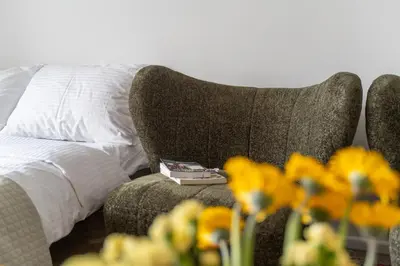 a book sitting on a couch next to a bed at Ducks in the yard - Self Check in in Vilnius