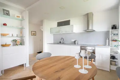 a kitchen and dining room with a wooden table and chairs at Ducks in the yard - Self Check in in Vilnius