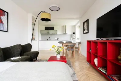 a bedroom with a red dresser and a living room at Ducks in the yard - Self Check in in Vilnius