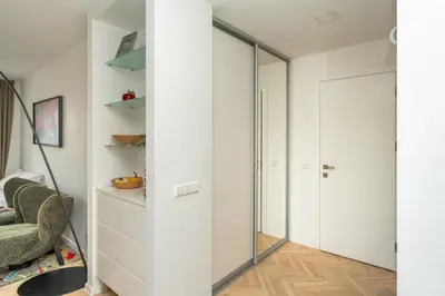 a mirror in a room with a couch and a chair at Ducks in the yard - Self Check in in Vilnius