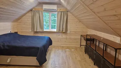 a bedroom with a bed in a wooden room at Viensėdis in Anykščiai
