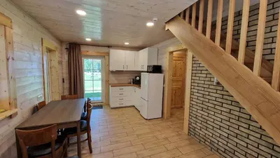 a kitchen with a table and a white refrigerator at Viensėdis in Anykščiai