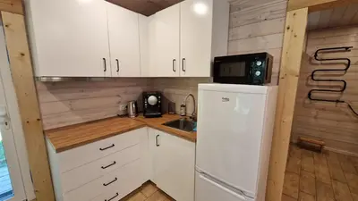 a kitchen with white cabinets and a refrigerator at Viensėdis in Anykščiai