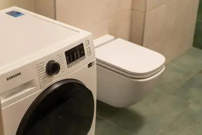 a washing machine and a toilet in a bathroom at Skansen Vilnius City Center in Vilnius
