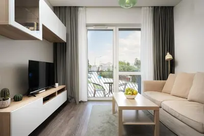 a living room with a couch and a tv at Skansen Vilnius City Center in Vilnius