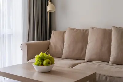 a bowl of fruit on a coffee table in front of a couch at Skansen Vilnius City Center in Vilnius